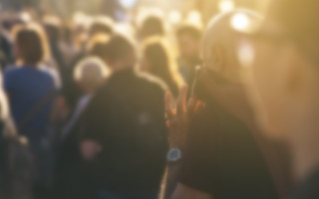 Defocused crowd attending political meeting